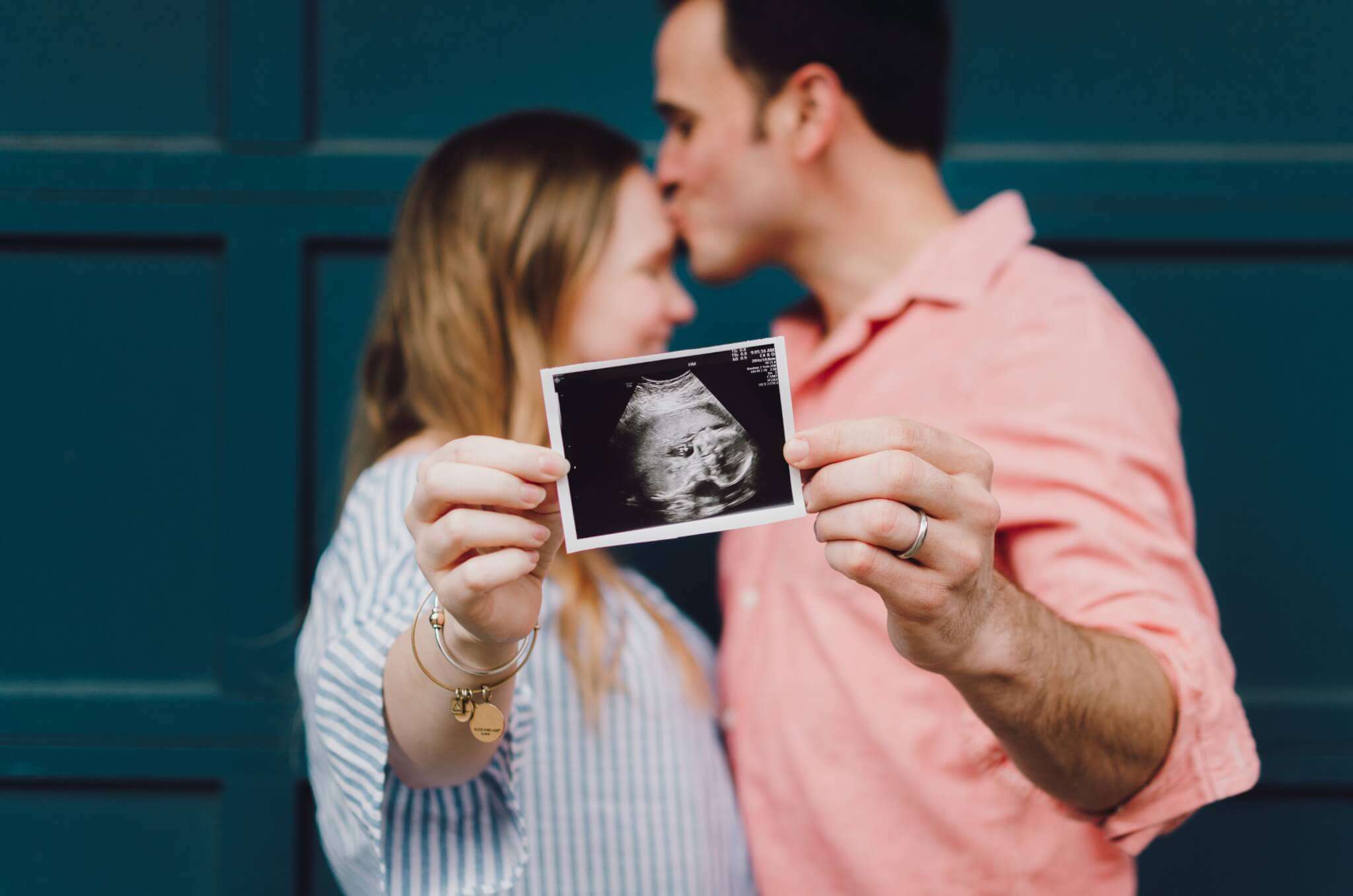 man and woman hold baby scan photo